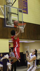 Jerel Moore dunks the ball to cap off a victory over Muscatine.  Photo by Tristan Spears.