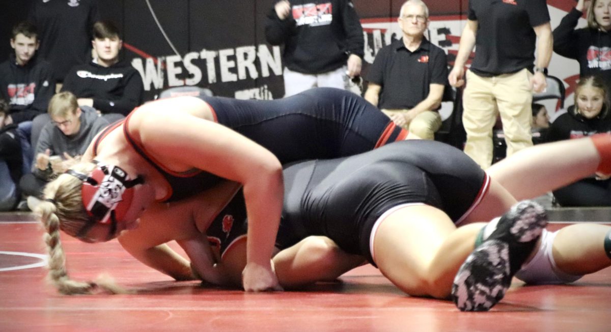 Molly Carlson ‘26 flips her opponent, preparing to win by pin in the first period.
