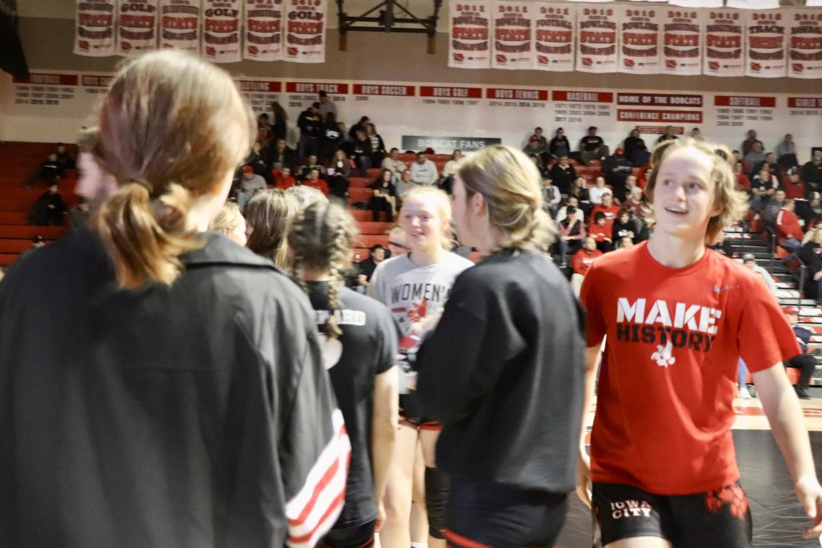 Sierra Pruessner ‘24 and the rest of the team celebrate after Molly Carlson ‘26 pins her opponent and City High wins.
