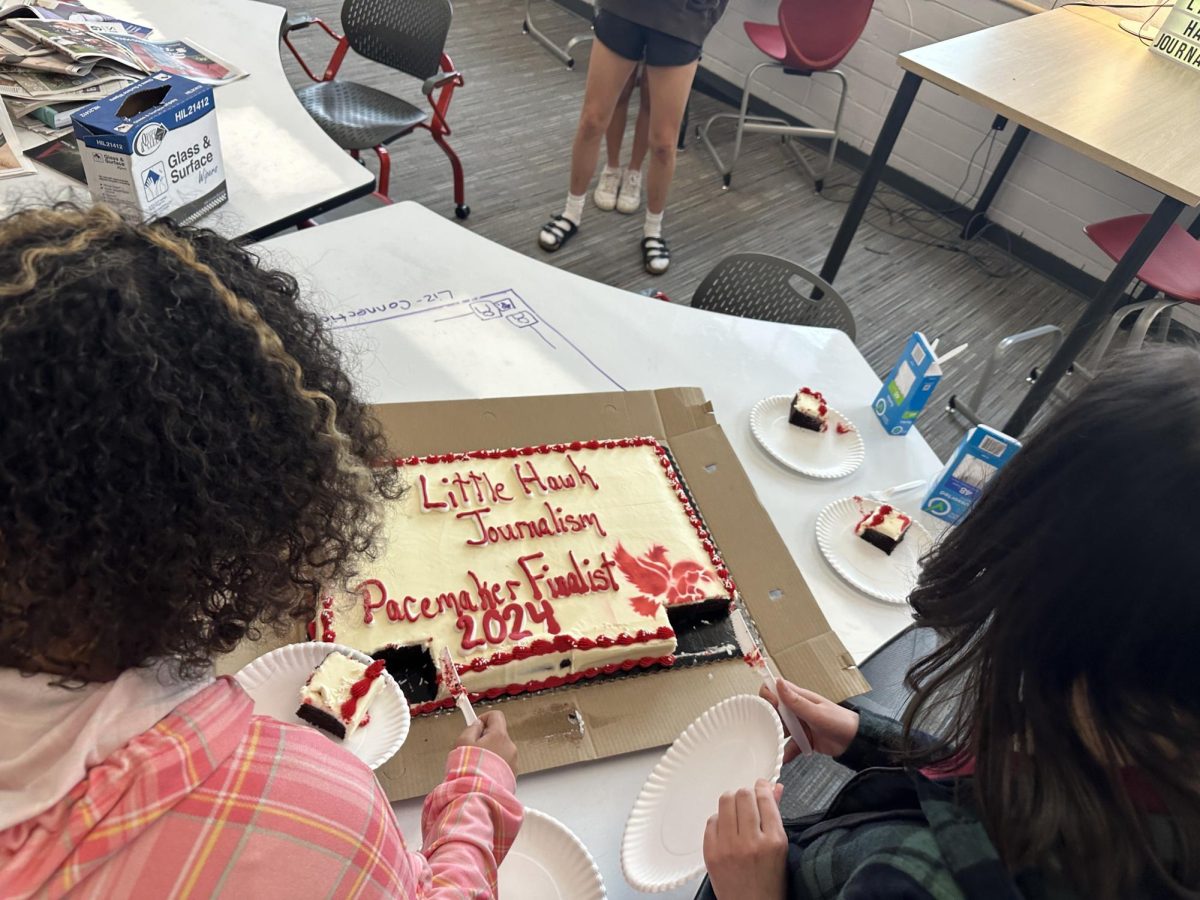 Tai Caputo '25 and Isabella Young '25 cut cake to celebrate being named Pacemaker Finalists