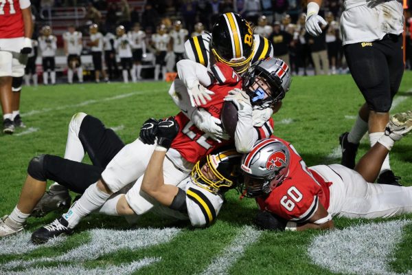 Gabe Egeland '25 gets tackled by 2 different Bettendorf players, after getting a hand off from Bobby Bacon '25, and gaining the 1st down.