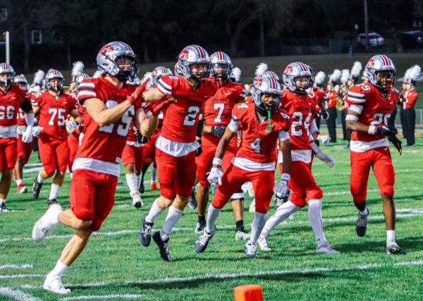 At the start of the game, the football team from City High rushes onto the field