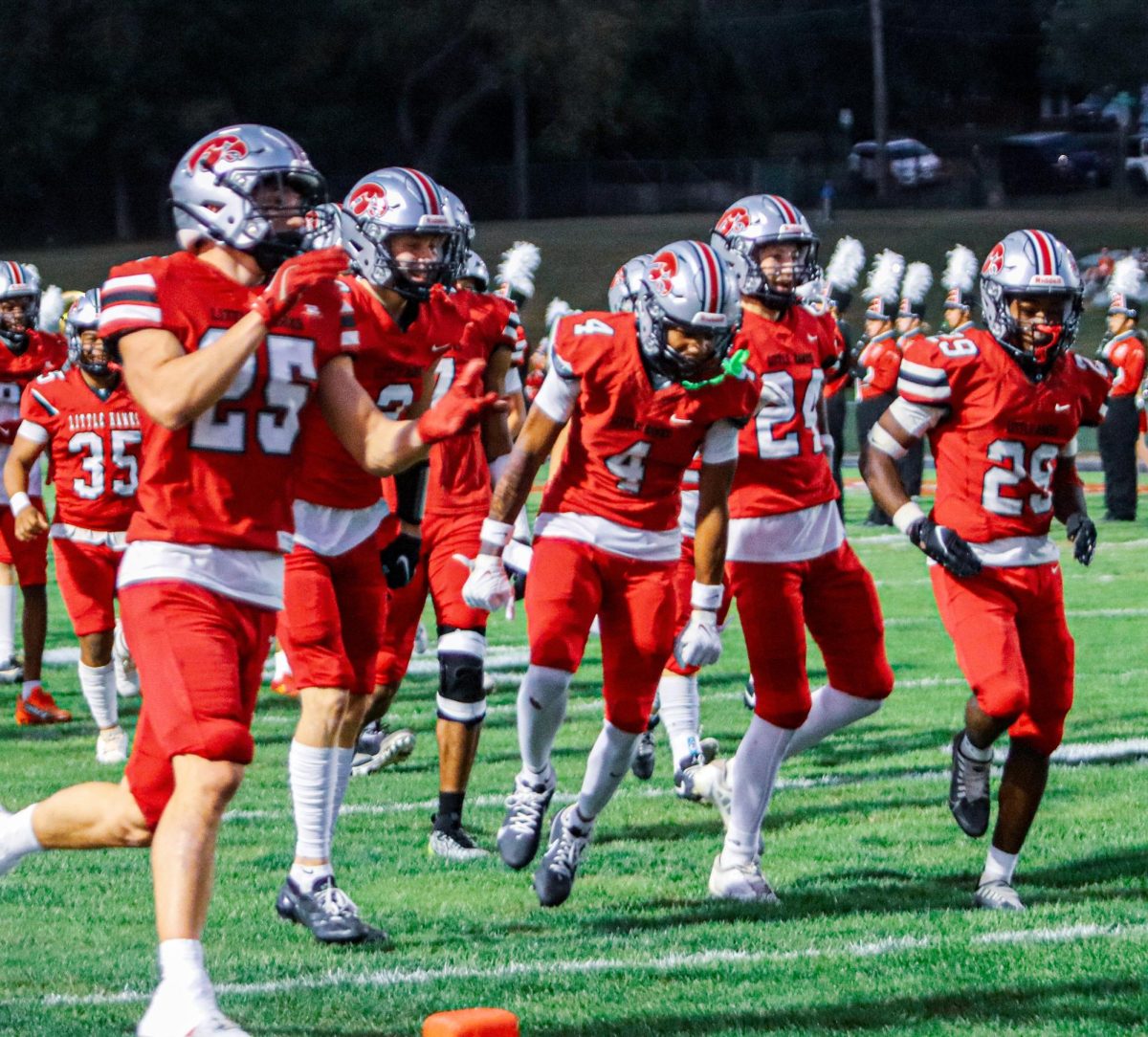 At the start of the game, the football team from City High rushes onto the field
