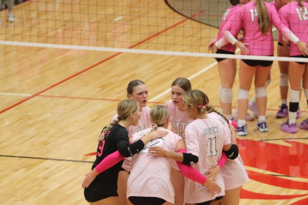 The team huddles after winning a point against Liberty Highschool. 