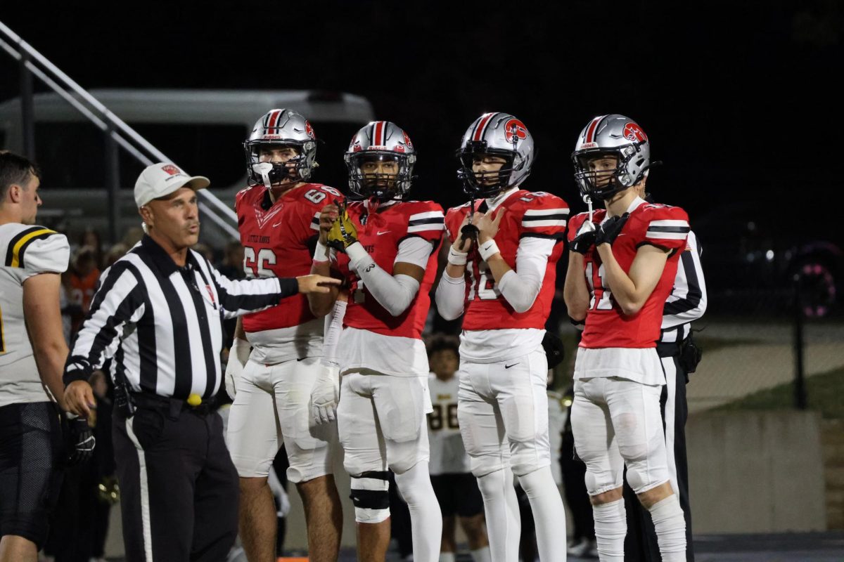 The team captains (Tyler Rindles '25, Dominic Salibi '25, Bobby Bacon '25, Connor Cross '25) finish the coin toss and receive the ball in the pre-game vs. Bettendorf.