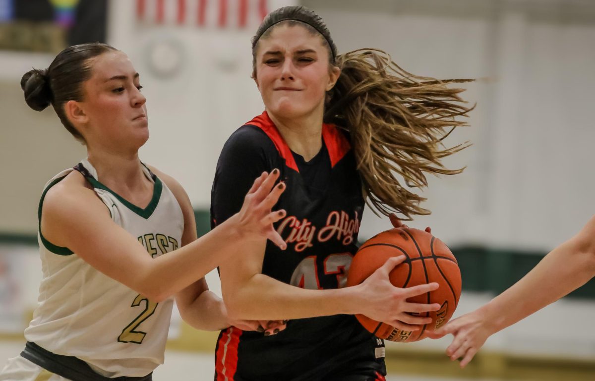 Tessa Driscoll '26 drives against West High in the first game of the year.  City will play West at City on January 25th.  Tessa is shooting 33% from the three-point line for the season.