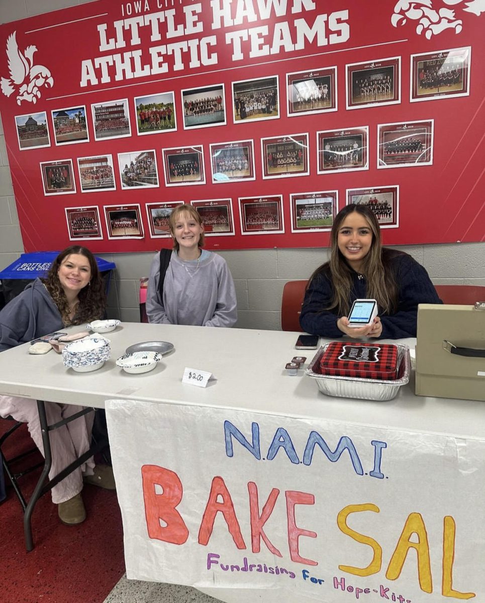 Students Maya Shannon '26, Rowyn Mass '26, and Adelaide Newton '26 sell baked goods for a NAMI Bake Sale. 