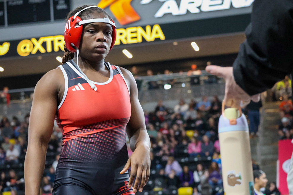 Shaona Emmanuel walks up to Coach Jeff Koenig after winning the match that secured her spot on the podium. She won this match by fall.