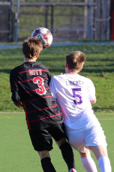 Seth Zeithamel '27 collides with a Liberty defender during a header. 