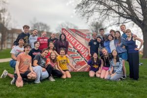 Members of the cast and crew of Urinetown pose in front of City High promoting the musical.